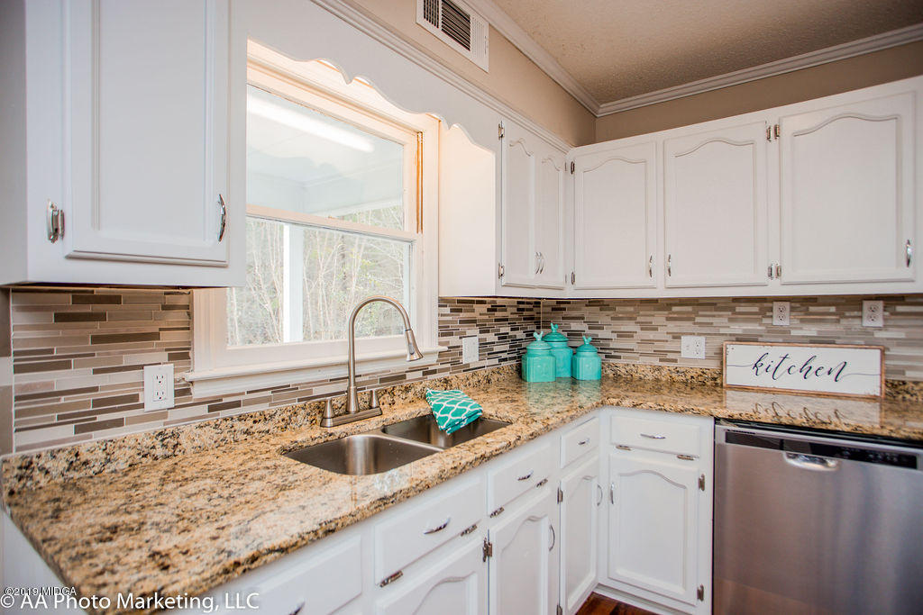 922 Woolfolk Road Fort Valley, GA 31030 - Photo 8 of 38 a kitchen with stainless steel appliances granite countertop a sink a stove and cabinets