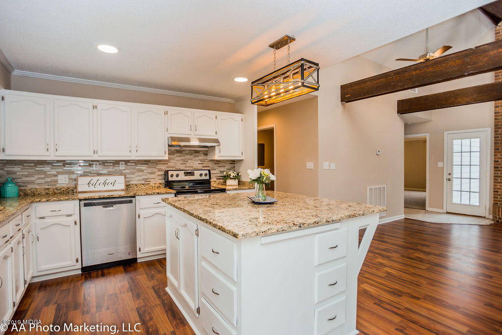 922 Woolfolk Road Fort Valley, GA 31030 - Photo 10 of 38 a kitchen with granite countertop a sink stove and cabinets