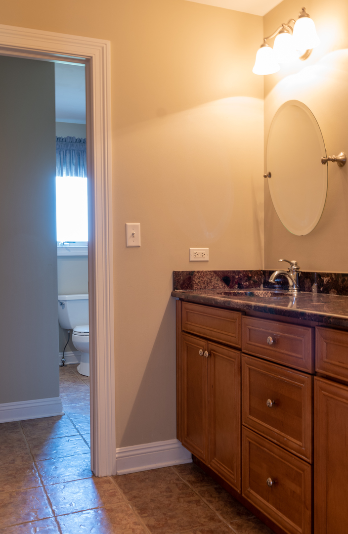 1500 Cherry Valley Road Bull Valley, IL 60050 - Photo 22 of 30 a bathroom with a granite countertop sink and a mirror