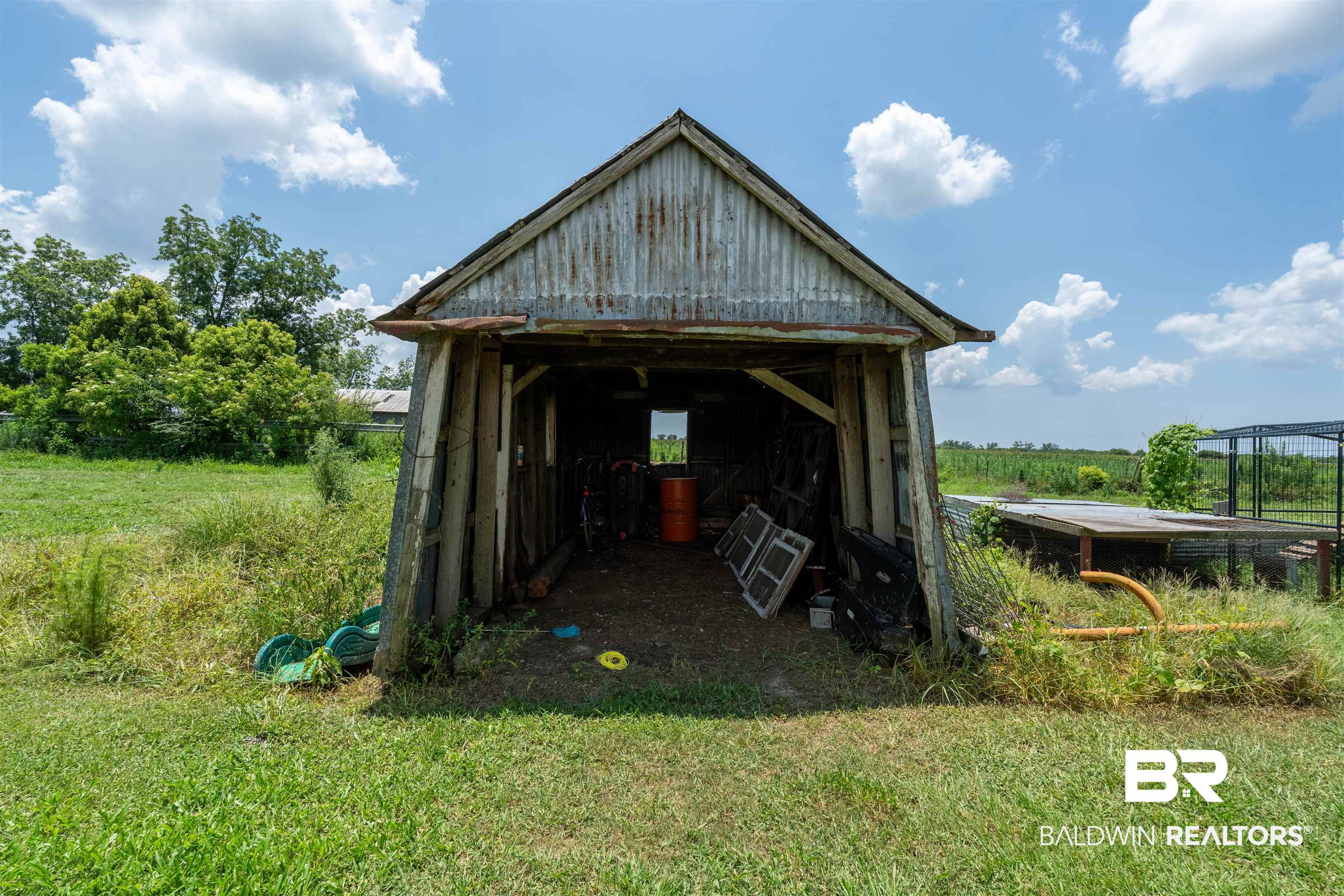 15575 Mikkelsen Road Summerdale, AL 36580 - Photo 32 of 68 Open-sided shed featuring a corrugated metal roof and exposed wood framing