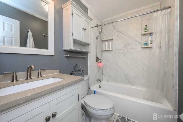 a bathroom with a granite countertop sink a toilet and shower