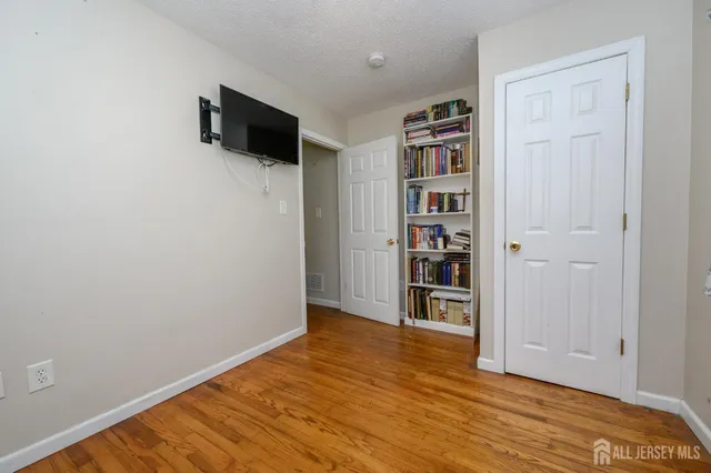 a view of empty room with wooden floor and cabinet