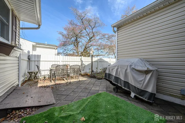 a view of a chair and table in backyard of the house
