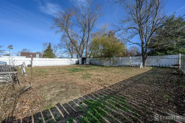 a view of backyard with wooden fence