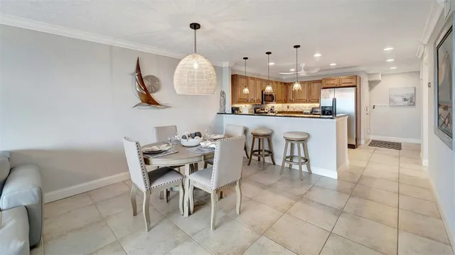 a view of a dining room and livingroom with furniture a rug a potted plant and a chandelier