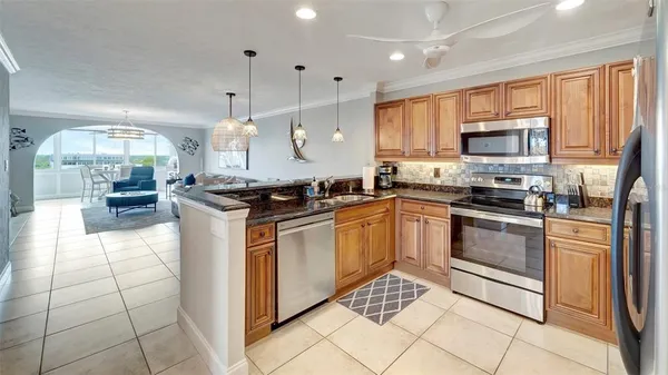 a kitchen with stainless steel appliances granite countertop a stove a sink and a refrigerator
