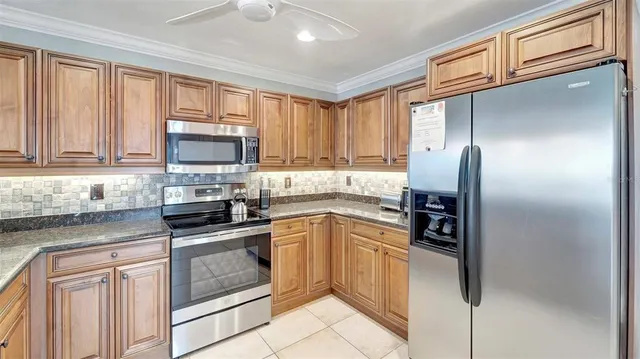 a kitchen with granite countertop a refrigerator stove and microwave