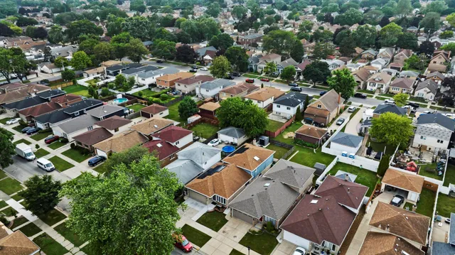 an aerial view of residential houses with outdoor space and trees