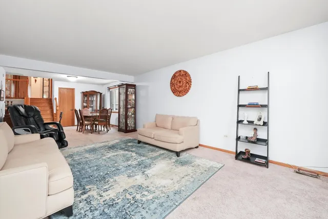 a living room with furniture a rug and white walls