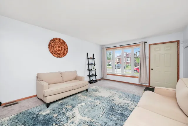 a living room with furniture a wall paintings and a large window