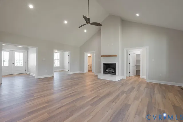 a view of an empty room with wooden floor and a fireplace