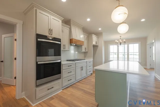 an open kitchen with fireplace and wooden floor