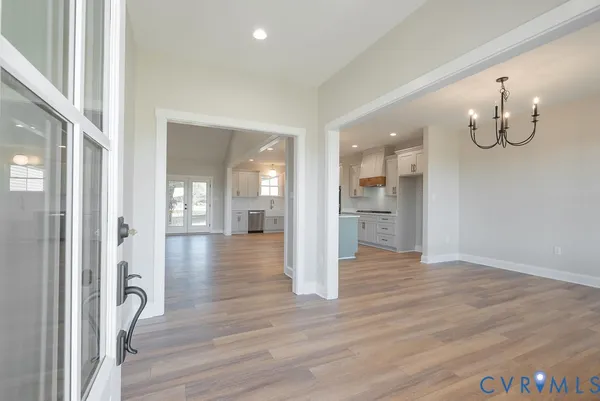a view of a hallway with wooden floor and a bathroom