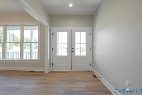 an empty room with wooden floor and windows