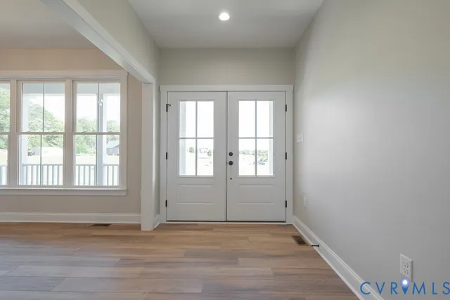 an empty room with wooden floor and windows