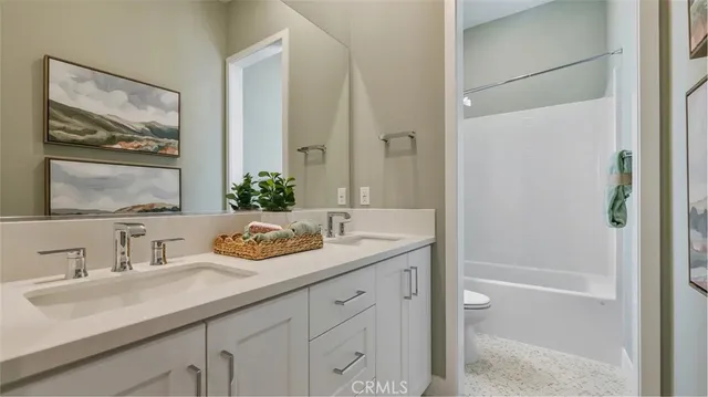 a bathroom with a granite countertop sink a mirror a vanity and a bathtub