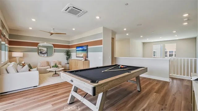 a kitchen with stainless steel appliances granite countertop a stove a sink dishwasher and a dining table with wooden floor