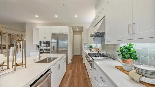 a kitchen with granite countertop a sink stove and refrigerator