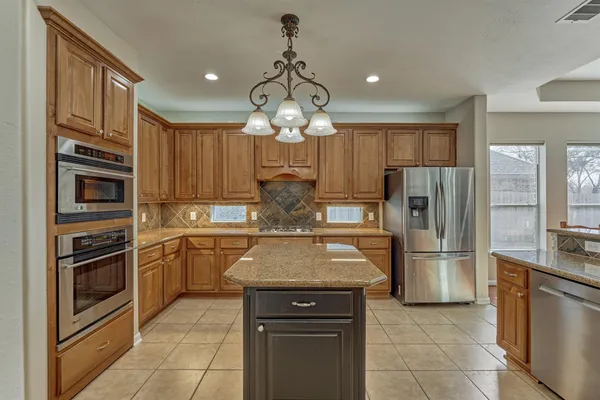 a kitchen with stainless steel appliances granite countertop a refrigerator oven a sink dishwasher and a refrigerator with a cabinets