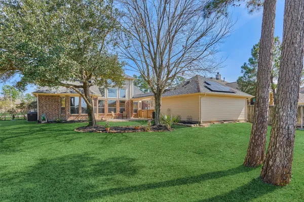 an aerial view of a house with yard and green space