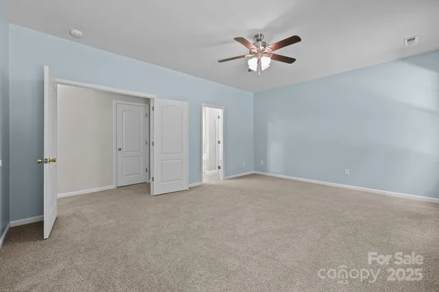 a spacious bathroom with a granite countertop double vanity sink a mirror and a shower