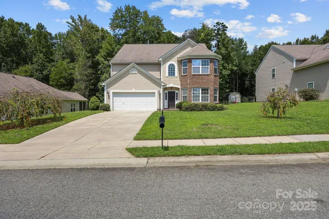a view of a house with a big yard plants and large trees