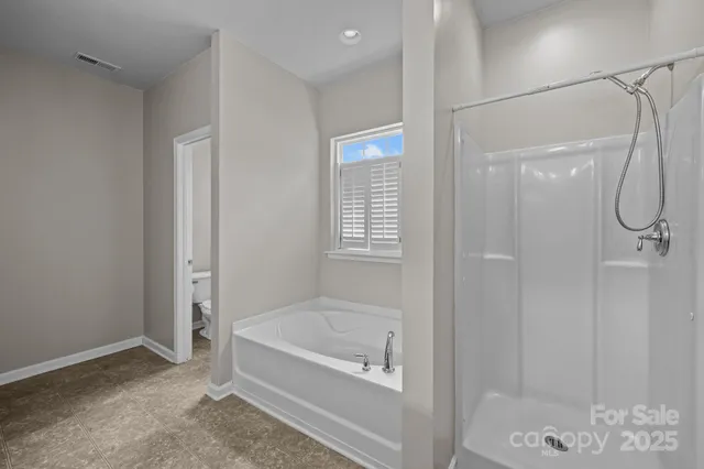 an empty room with windows and ceiling fan