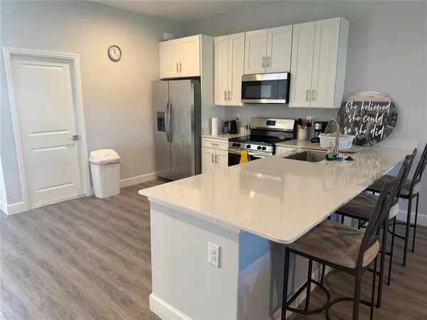 a kitchen with stainless steel appliances a table chairs and a refrigerator