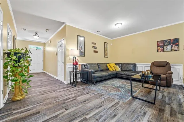 a living room with furniture and a wooden floor