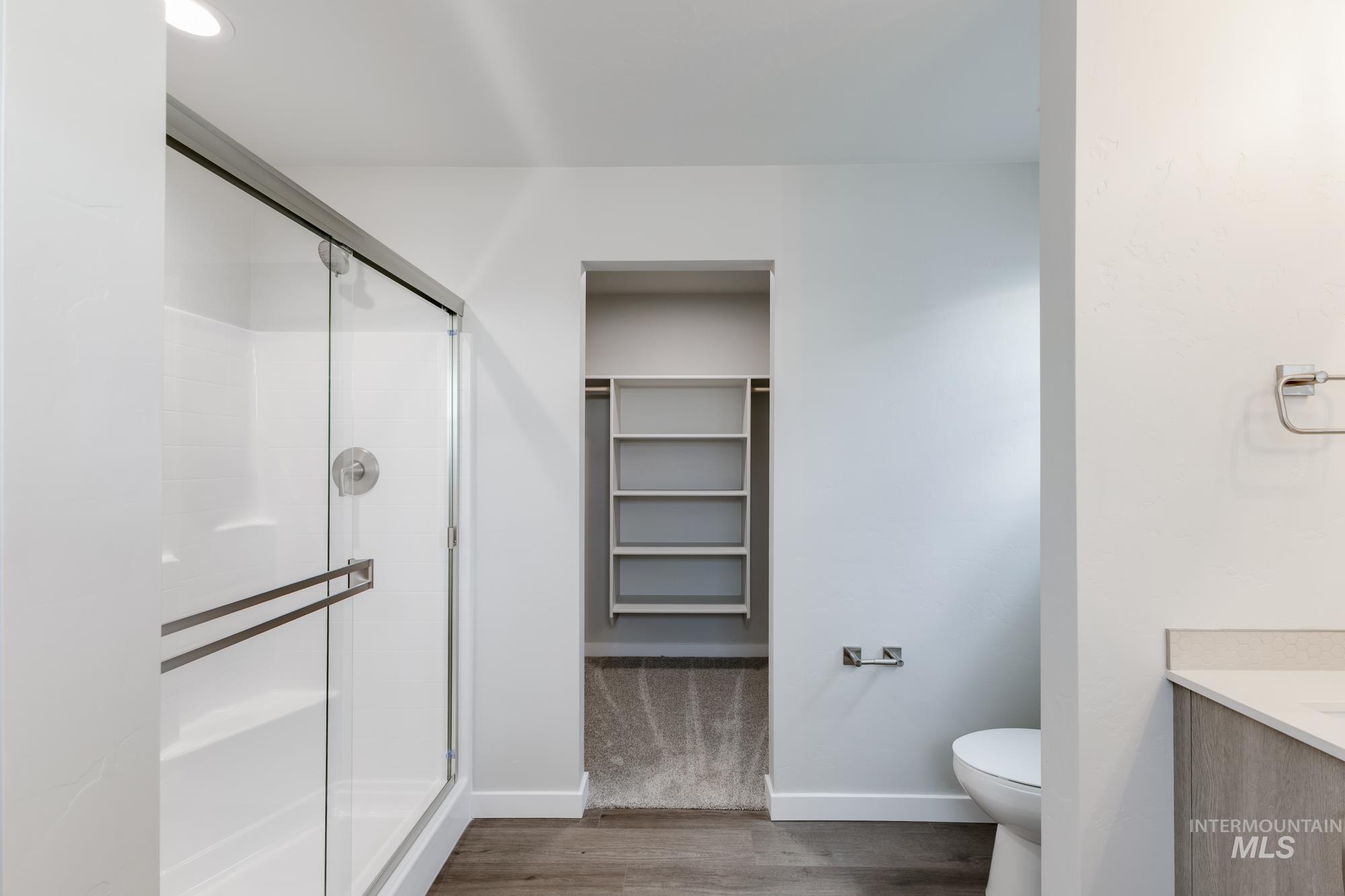 903 North Mirror Creek Way Meridian, ID 83642 - Photo 22 of 24 Full bathroom with a spacious closet, vanity, a shower stall, and wood finished floors