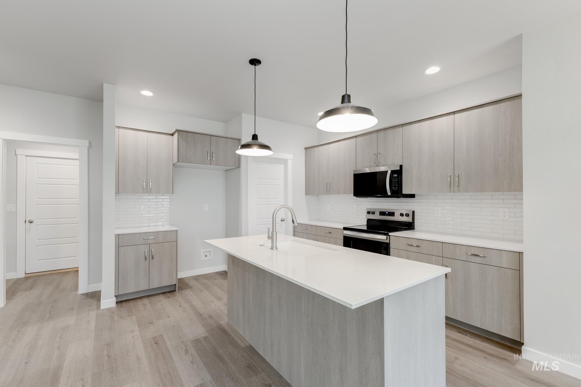 903 North Mirror Creek Way Meridian, ID 83642 - Photo 4 of 24 Kitchen with tasteful backsplash, light brown cabinets, appliances with stainless steel finishes, pendant lighting, and recessed lighting