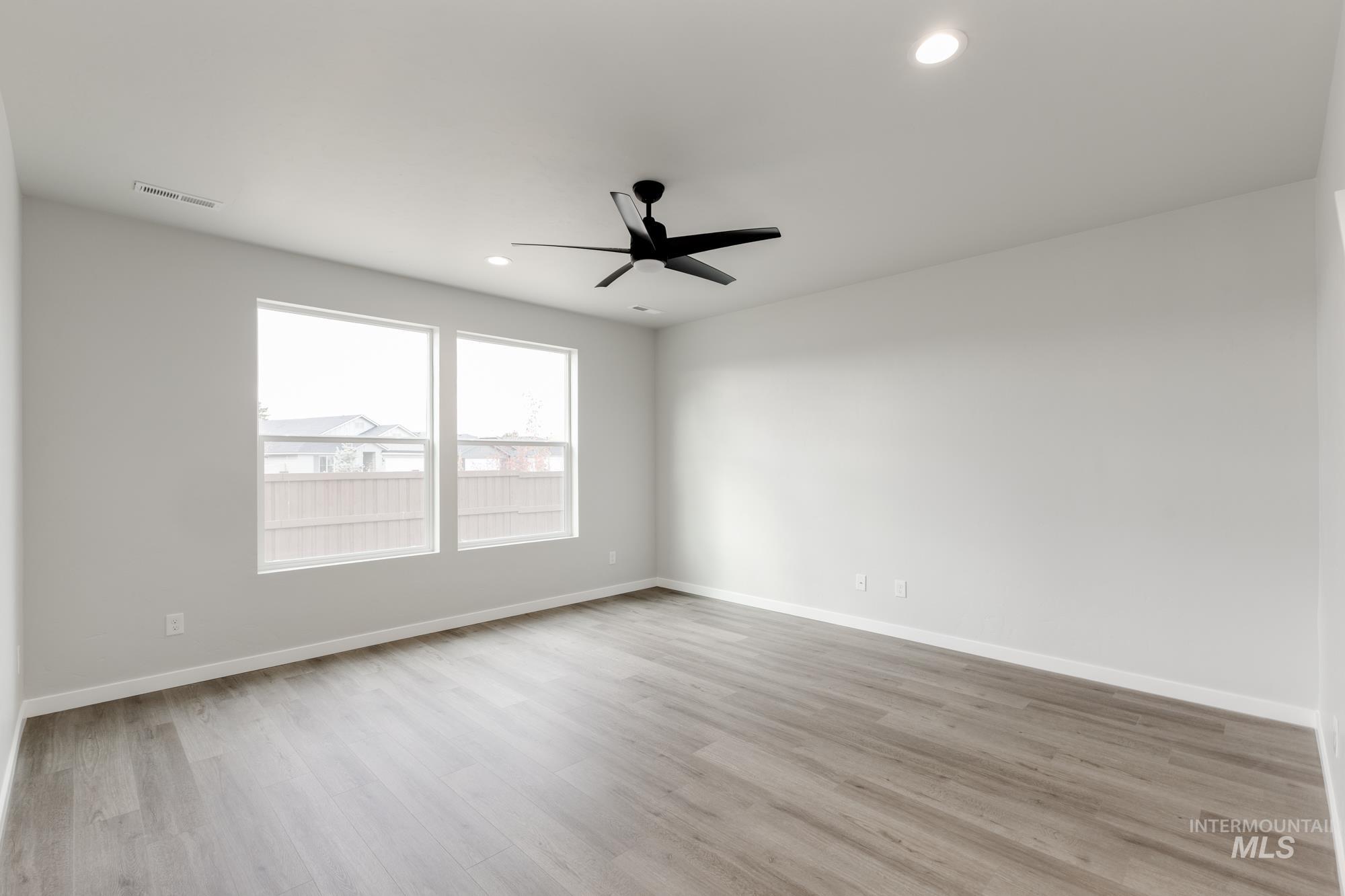 903 North Mirror Creek Way Meridian, ID 83642 - Photo 7 of 24 Empty room featuring light wood-style flooring, recessed lighting, and a ceiling fan