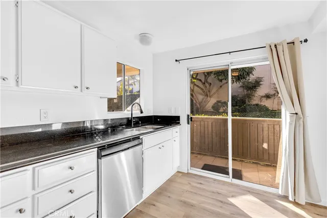 a kitchen with granite countertop a sink and a refrigerator
