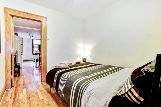 a bedroom with a bed and wooden floor