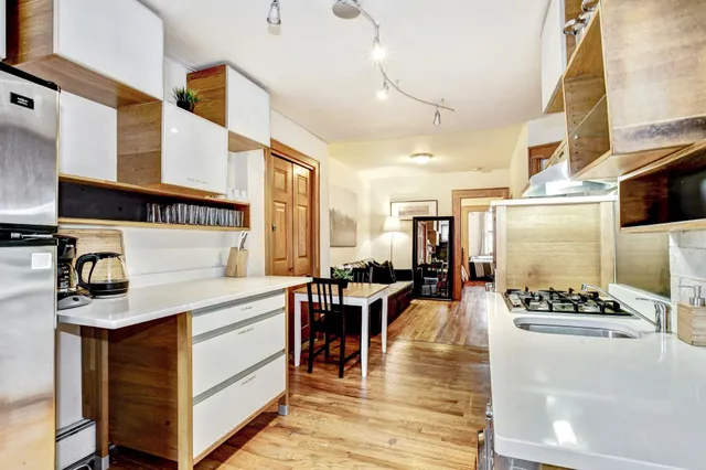 a kitchen with stainless steel appliances kitchen island granite countertop a table and chairs in it