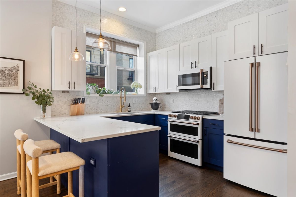 514 North Armour Street, Unit 1F Chicago, IL 60642 - Photo 7 of 18 a kitchen with stainless steel appliances white cabinets and wooden floor