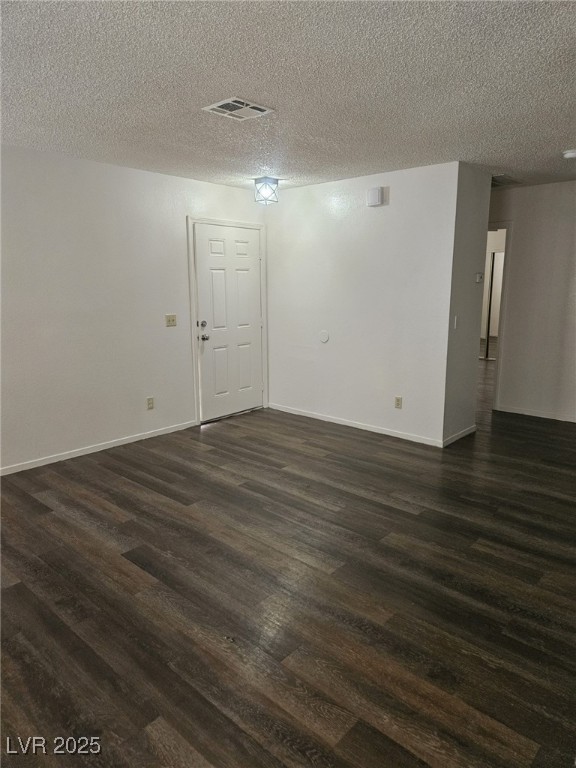 5576 West Rochelle Avenue, Unit 31A Las Vegas, NV 89103 - Photo 2 of 11 Empty room featuring dark wood-type flooring, a textured ceiling, and baseboards