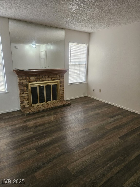 5576 West Rochelle Avenue, Unit 31A Las Vegas, NV 89103 - Photo 3 of 11 Unfurnished living room with wood finished floors, a fireplace, a textured ceiling, baseboards, and plenty of natural light