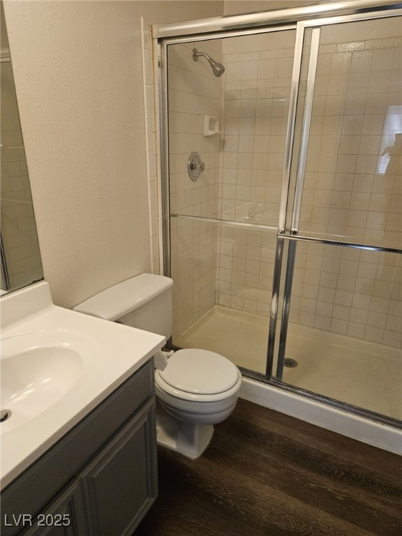 5576 West Rochelle Avenue, Unit 31A Las Vegas, NV 89103 - Photo 7 of 11 Bathroom with vanity, a stall shower, toilet, wood finished floors, and a textured wall
