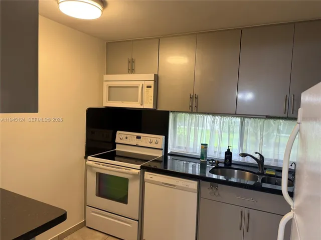 a kitchen with stainless steel appliances a stove a sink and a microwave