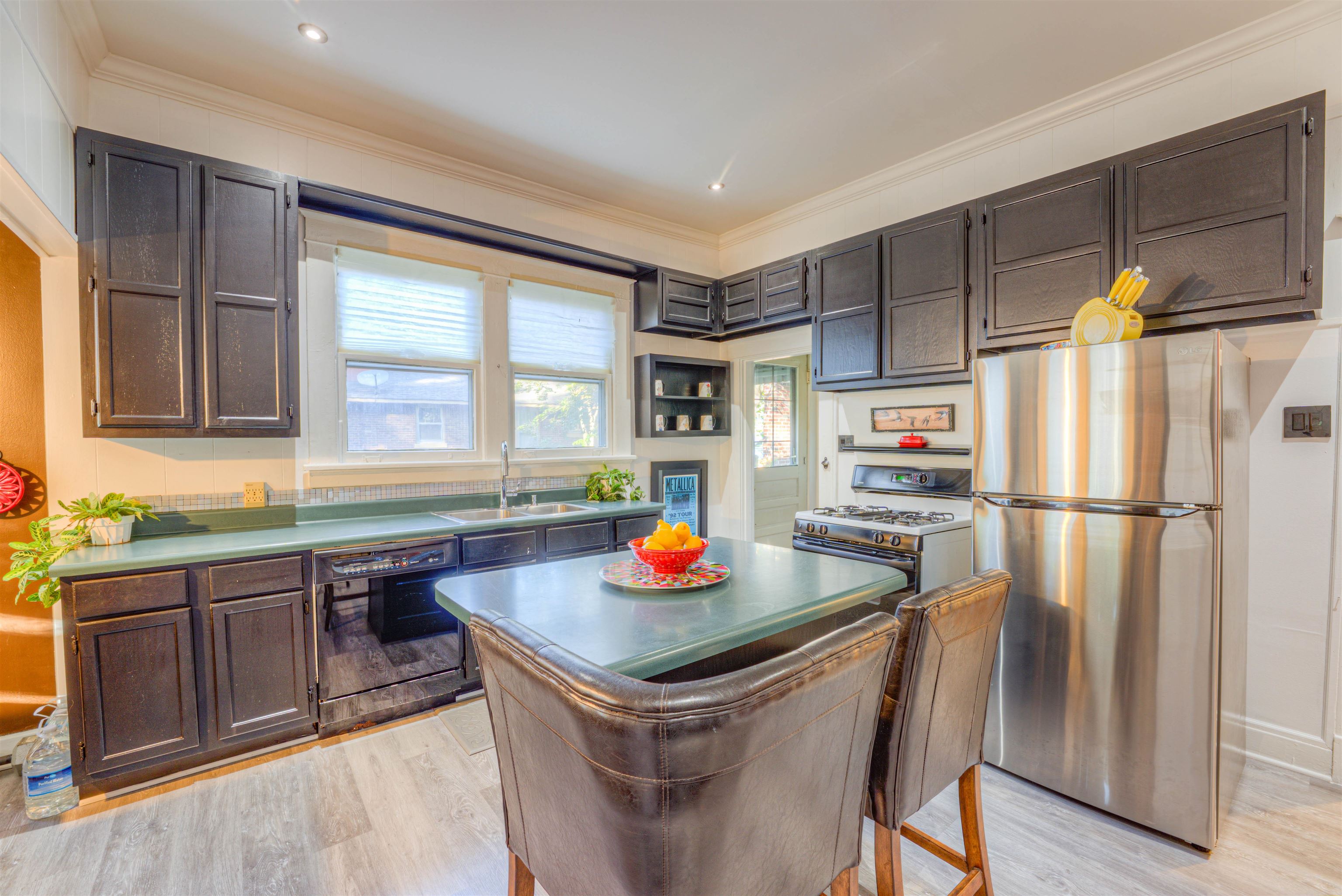 511 Ellsworth Street Memphis, TN 38111 - Photo 11 of 29 a kitchen with stainless steel appliances granite countertop a refrigerator a sink dishwasher and a dining table with wooden floor