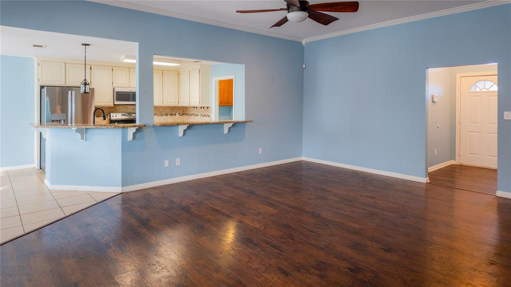 124 Topaz Circle Hewitt, TX 76643 - Photo 5 of 29 Unfurnished living room with ornamental molding, dark wood-type flooring, and ceiling fan