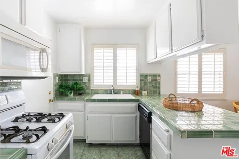 a kitchen with a stove top oven and refrigerator
