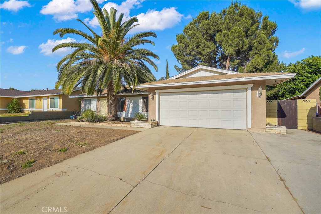 1493 North Yucca Avenue Rialto, CA 92376 - Photo 1 of 1 a front view of a house with a yard and garage