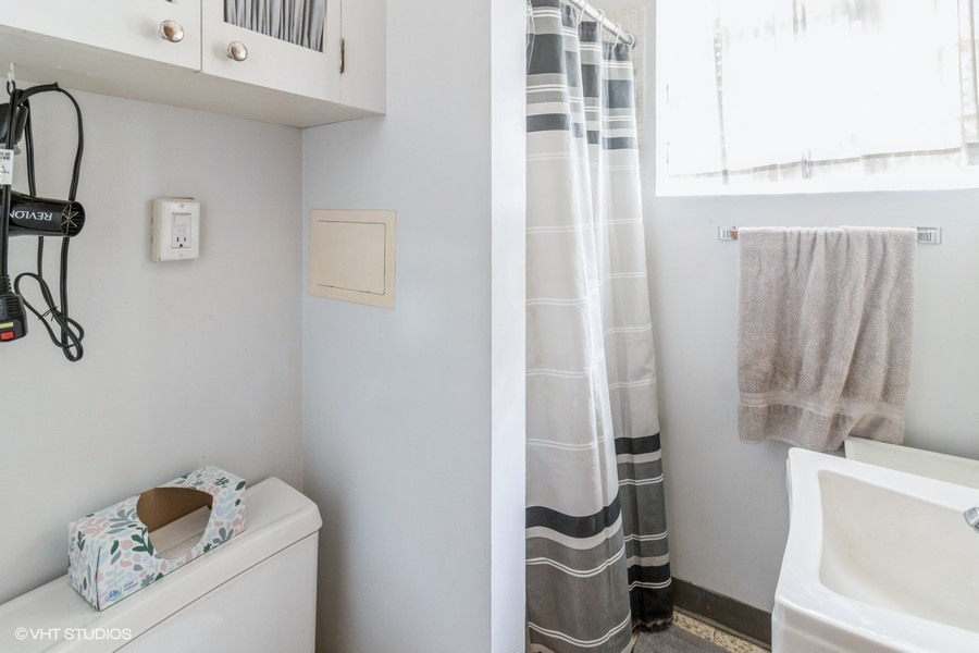 233 High Ridge Road Hillside, IL 60162 - Photo 5 of 10 a bathroom with a sink and a shower curtain
