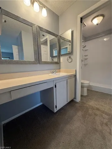 a bathroom with a double vanity sink a toilet and mirror