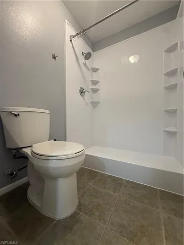 a white toilet sitting next to a bath tub and a shower