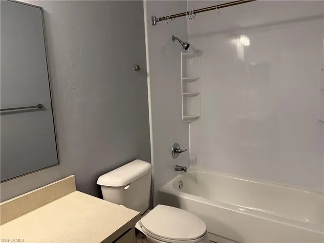 a white toilet sitting next to a bath tub and a shower