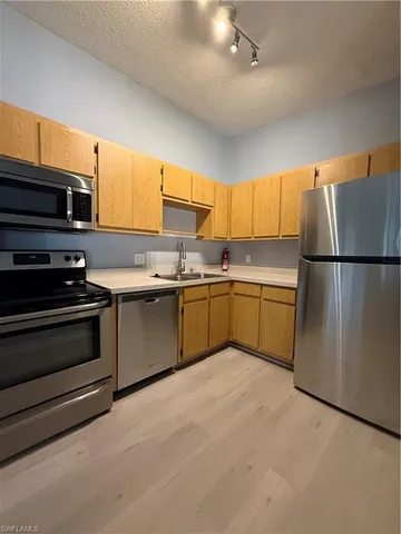 a kitchen with a sink stainless steel appliances and cabinets