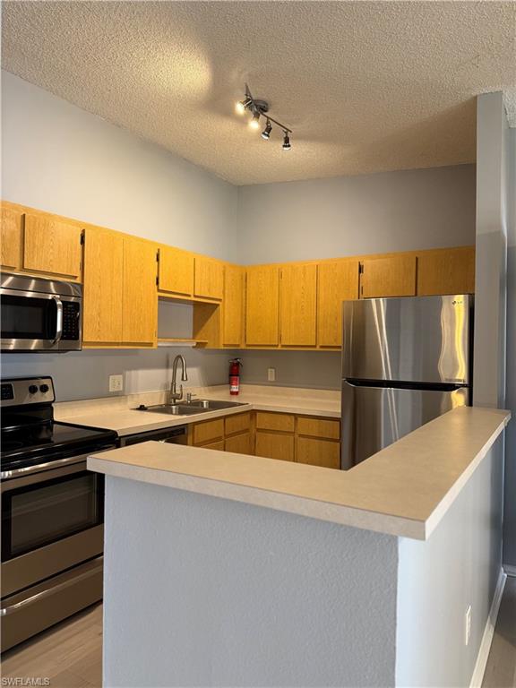 6492 Royal Woods Drive, Unit 5 Fort Myers, FL 33908 - Photo 9 of 28 a kitchen with stainless steel appliances a sink a stove and a refrigerator